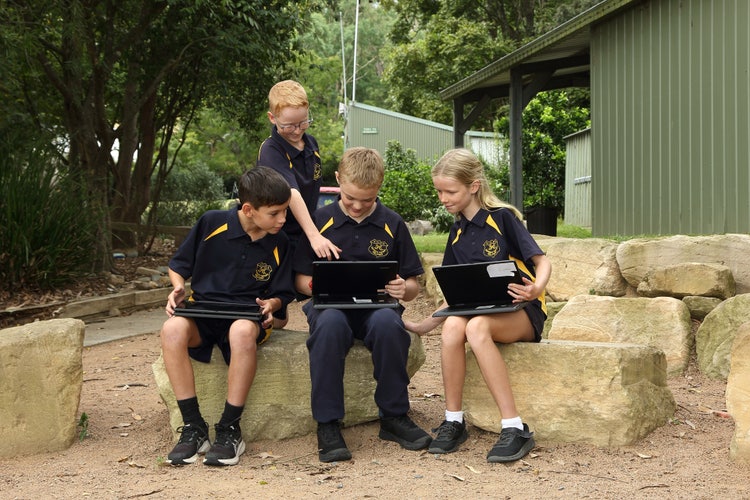 Students using computers in KVPS outdoor learning area