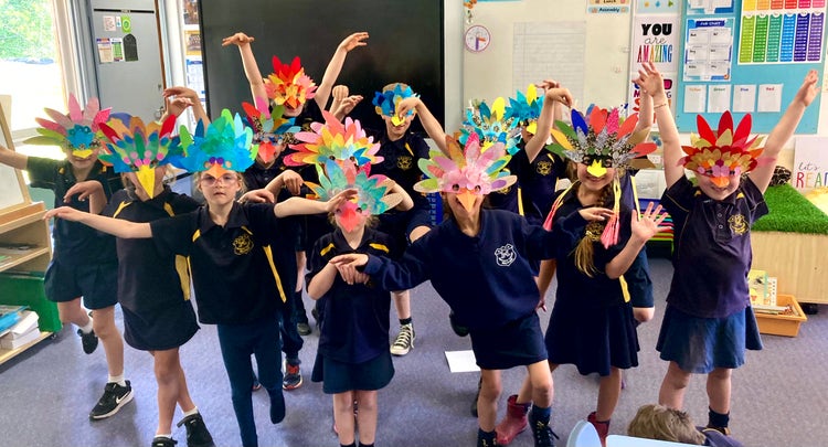 The students from 1/2 wearing the beautiful masks they made